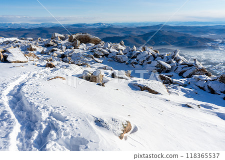 Touristic path trodden in the snow. view of the mountains blue sky and the village. winter landscape 118365537