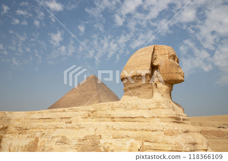 Beautiful profile of the Great Sphinx including pyramids of Menkaure and Khafre in the background on a clear sunny, blue sky day in Giza, Egypt Beautiful profile of the Great Sphinx including pyramids of Menkaure and Khafre in the background on a clear sunny, blue sky day in Giza, Egypt 118366109