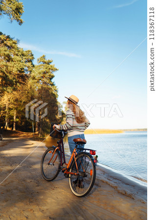 Happy active young woman on bike in autumn park at sunset. Concept of people, recreation, active lifestyle. Happy active young woman on bike in autumn park at sunset. Concept of people, recreation, active lifestyle. 118367118