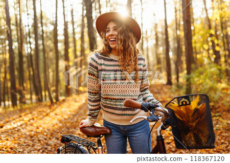 Happy active young woman on bike in autumn park at sunset. Concept of people, recreation, active lifestyle. Happy active young woman on bike in autumn park at sunset. Concept of people, recreation, active lifestyle. 118367120