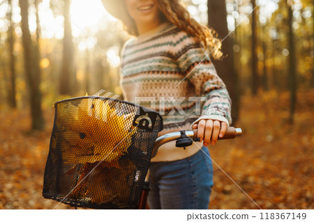 Autumn bouquet of yellow and orange leaves lying in a bicycle basket in a sunny autumn park. Autumn bouquet of yellow and orange leaves lying in a bicycle basket in a sunny autumn park. 118367149