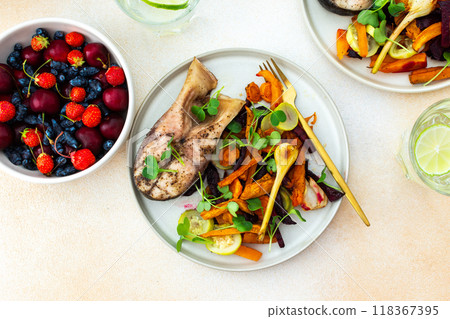 Enjoy baked silver carp with a medley of roasted vegetables including carrots, zucchini, beets, and garlic, paired with fresh seasonal fruits Enjoy baked silver carp with a medley of roasted vegetables including carrots, zucchini, beets, and garlic, paired with fresh seasonal fruits 118367395