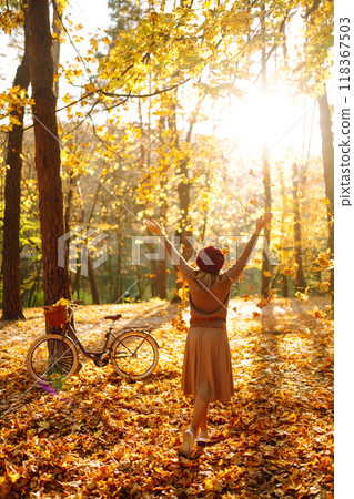 Beautiful Woman throws up autumn leaves and having fun in autumn park. Relaxation, enjoying. Beautiful Woman throws up autumn leaves and having fun in autumn park. Relaxation, enjoying. 118367503