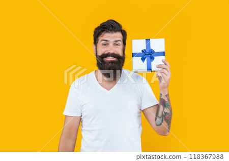 happy bearded guy with present box in studio. guy with present isolated on yellow background. 118367988
