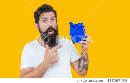 surprised birthday guy holding present box. bearded guy with present box in studio. surprised birthday guy holding present box. bearded guy with present box in studio. 118367989
