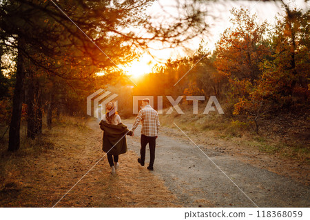 Happy couple in love newlyweds in casual clothes travel together in the autumn forest in nature. 118368059