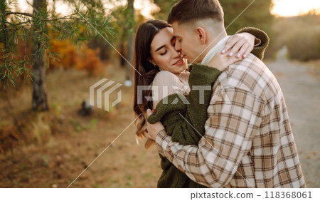 Happy couple in love newlyweds in casual clothes travel together in the autumn forest in nature. Happy couple in love newlyweds in casual clothes travel together in the autumn forest in nature. 118368061