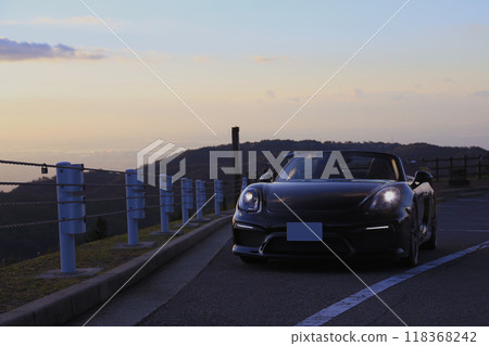 A shiny black convertible bathed in the morning sun 118368242