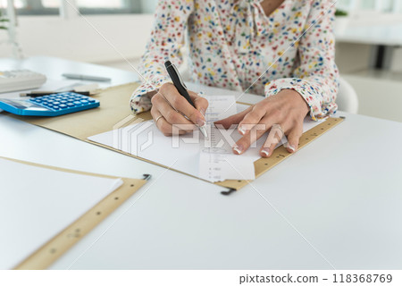 Accountant summing up the numbers writing on a printout receipt 118368769