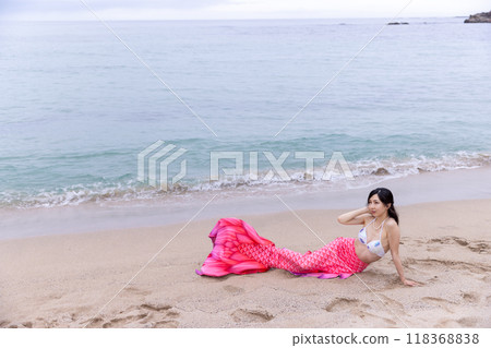 年輕的女美人魚躺在海邊的沙灘上 118368838