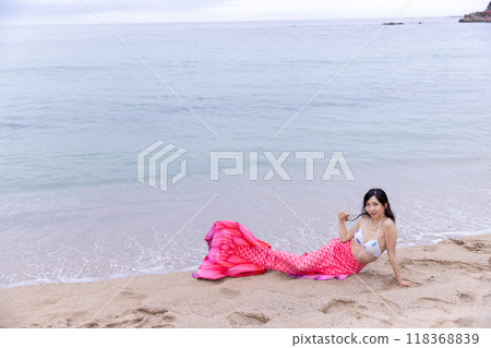 年輕的女美人魚躺在海邊的沙灘上 118368839