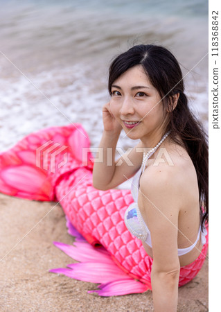 年輕的女美人魚躺在海邊的沙灘上 118368842