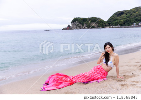 年輕的女美人魚躺在海邊的沙灘上 118368845