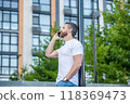 man has phone call standing outdoor. man having phone call in the street. man call 118369473