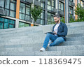 freelancer man with laptop sit outdoor. freelancer man in the street. freelancer man with pc outside 118369475