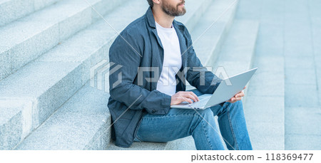 cropped view of man blogging online in the street. man blogging online with pc outside. cropped view of man blogging online in the street. man blogging online with pc outside. 118369477