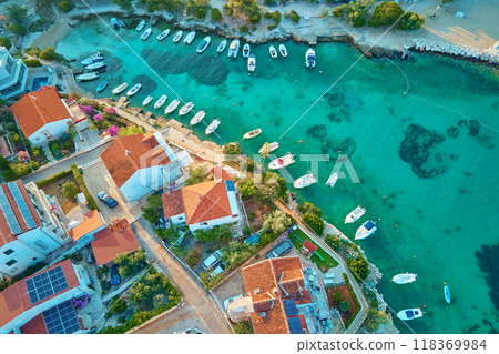 Birds eye view of sea coast with small town along seashore. Aerial top view of coastal village with red-roofed houses and boats near shore. Tourist town Rogoznica in Croatia on Adriatic Sea 118369984
