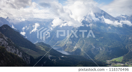 Day alpine landscape scenery with green valley, lake and snowy mountain peaks in clouds, Germany 118370496