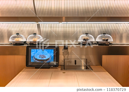 [Japan] A Japanese conveyor belt sushi restaurant, seen from the front, with a conveyor belt carrying sushi plates. 118370729