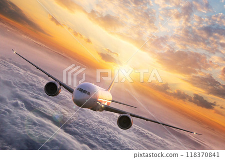 Passengers commercial airplane flying above clouds in sunset light. Concept of fast travel, holidays and business. 118370841