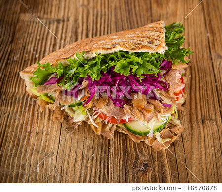 Doner Kebab Doner Kebap fast food snack in flatbread on a wooden table Doner Kebab Doner Kebap fast food snack in flatbread on a wooden table 118370878