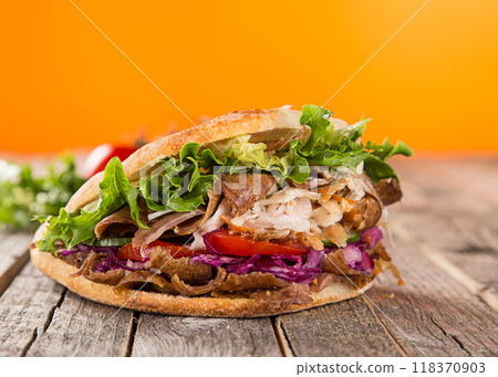 Doner Kebab Doner Kebap fast food snack in flatbread on a wooden table Doner Kebab Doner Kebap fast food snack in flatbread on a wooden table 118370903