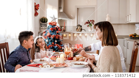 Happy family eating during the Christmas lunch Happy family eating during the Christmas lunch 118371412