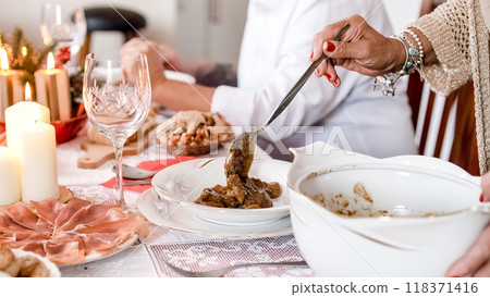 Woman serving food at the table at Christmas Woman serving food at the table at Christmas 118371416