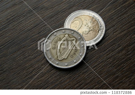 Used coins on a dark wooden table. Irish 2 euro coins Used coins on a dark wooden table. Irish 2 euro coins 118372886