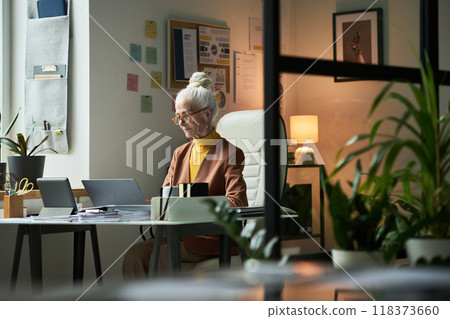 Senior Woman Working at Modern Office Desk Holding Paper Senior Woman Working at Modern Office Desk Holding Paper 118373660