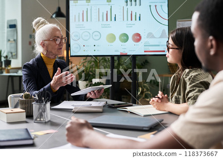 Senior Businesswoman Presenting Data to Diverse Team Senior Businesswoman Presenting Data to Diverse Team 118373667