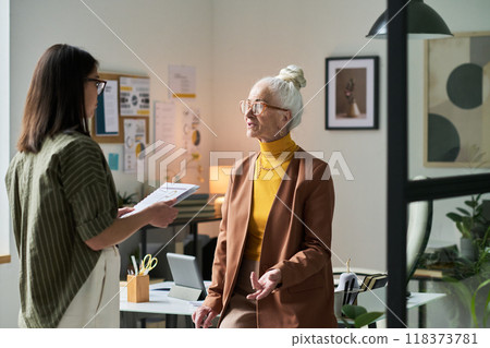 Discussing Office Projects with Colleague in Workspace Discussing Office Projects with Colleague in Workspace 118373781