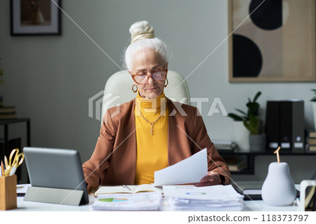 Senior Business Woman Reviewing Financial Documents Senior Business Woman Reviewing Financial Documents 118373797
