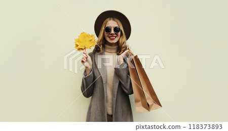 Autumn portrait of beautiful happy woman with shopping bag, stylish girl holding yellow maple leaves Autumn portrait of beautiful happy woman with shopping bag, stylish girl holding yellow maple leaves 118373893