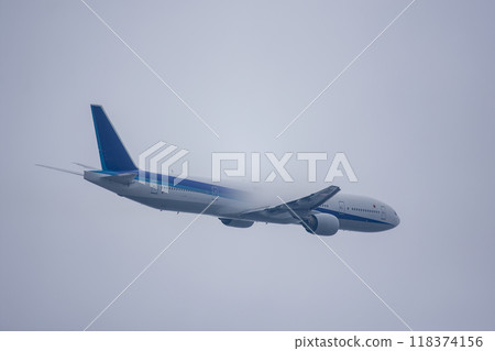 A passenger plane takes off covered in vapor 118374156