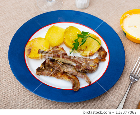 Roasted lamb ribs with boiled potato and greens 118377062