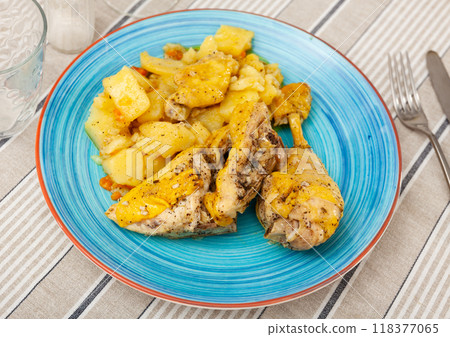 Baked chicken drumsticks and potatoes at plate closeup Baked chicken drumsticks and potatoes at plate closeup 118377065