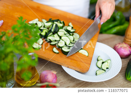 Female hands cuts vegetables on cutting board Female hands cuts vegetables on cutting board 118377071