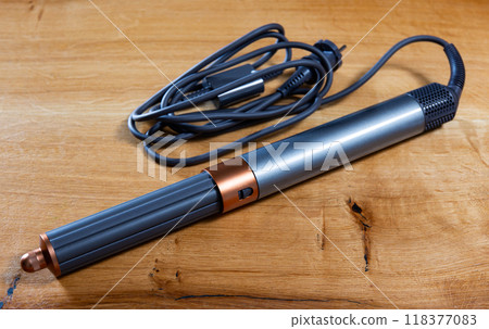 Hair styling tool for creating curls on wooden table 118377083