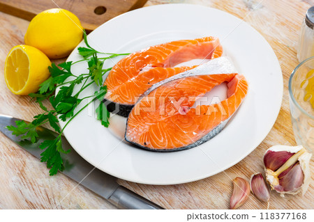 Salmon slice on plate with garlic, herbs and lemon Salmon slice on plate with garlic, herbs and lemon 118377168