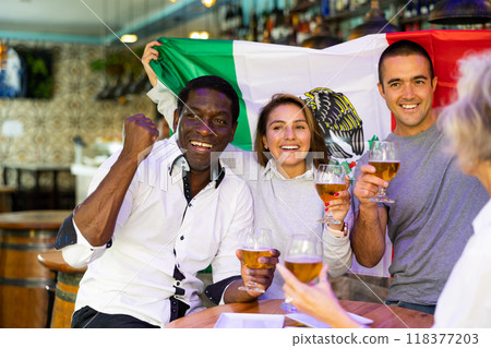 Joyful fans of the Mexican team celebrating the victory in night bar 118377203