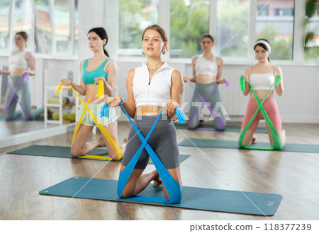 Group of young women doing pilates with band 118377239