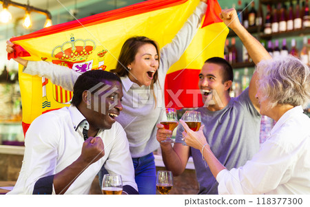 Men and women watching sport on tv together at bar, screaming cheerful and waving flag of Spain 118377300