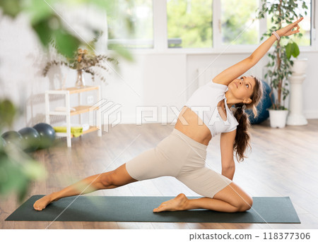 Experienced girl fitness club teacher performs deadbolt pose, parighasana Experienced girl fitness club teacher performs deadbolt pose, parighasana 118377306
