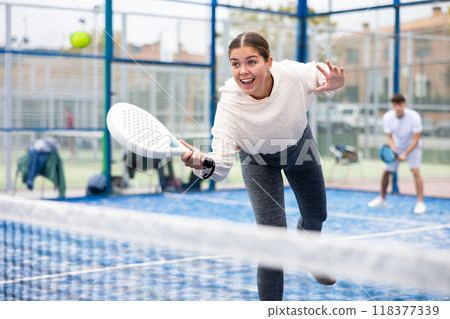 Young female paddle tennis player performing forehand 118377339