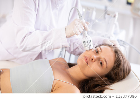 Young girl undergoing cosmetic facial treatment using cold hammer Young girl undergoing cosmetic facial treatment using cold hammer 118377380