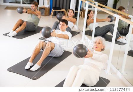 People different ages practicing pilates with ball at group class in yoga studio 118377474