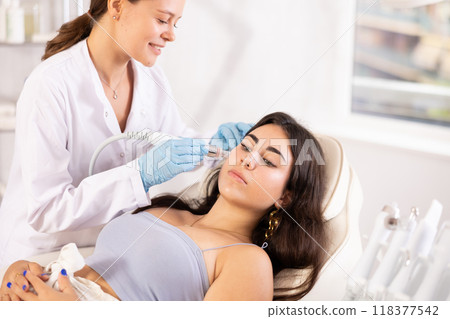 European doctor making Beauty procedure to brunette girl (skin cleaning) 118377542