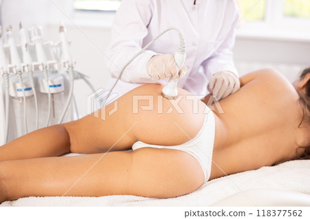 Cosmetic high-frequency ultrasound procedure on buttocks of female client in cosmetology clinic 118377562