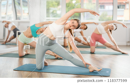 Group of girls doing Pilates or yoga - stretching the body in various poses 118377599